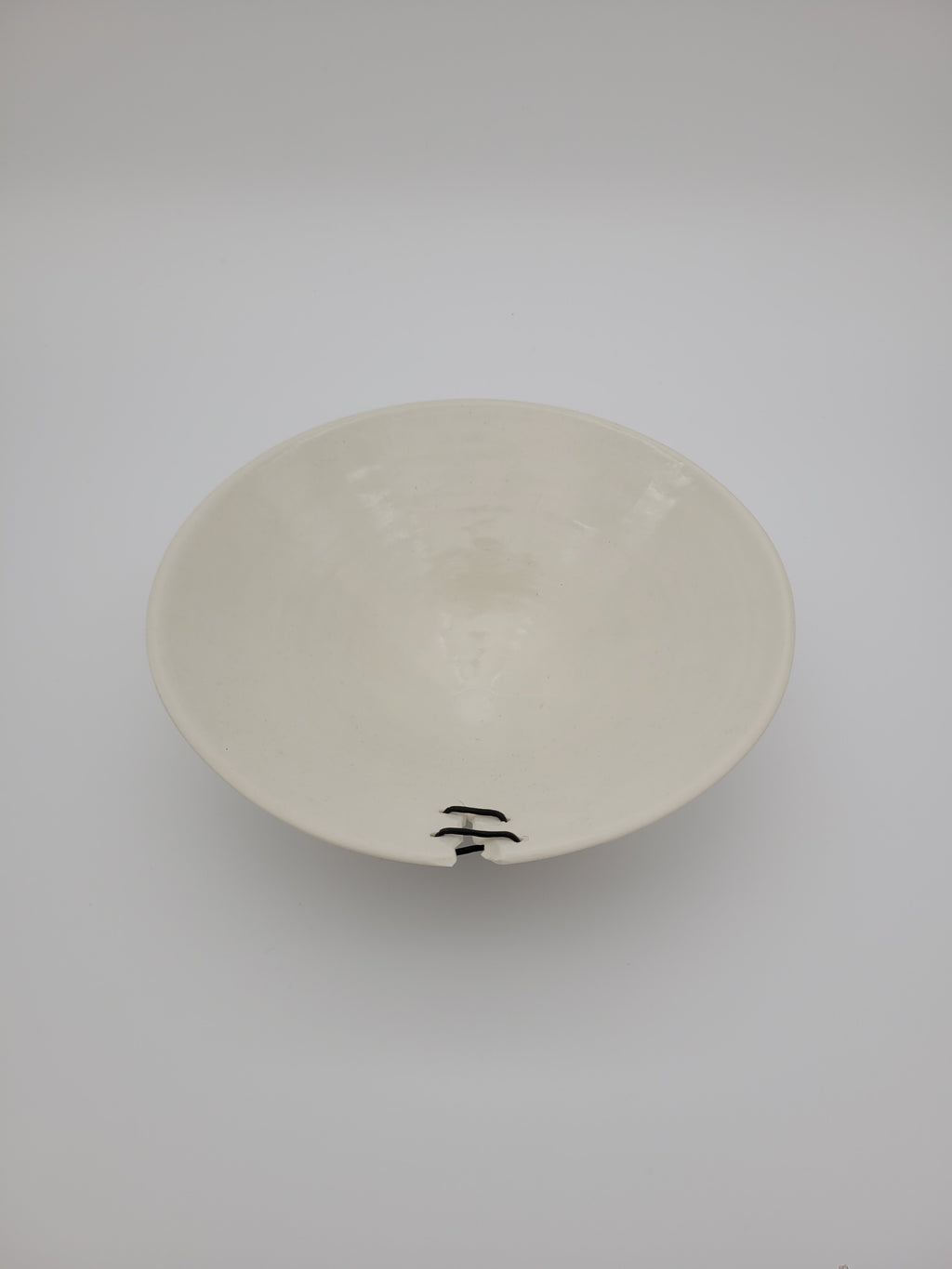 White ceramic bowl, medium size, with filigree detail and decorative opening at rim