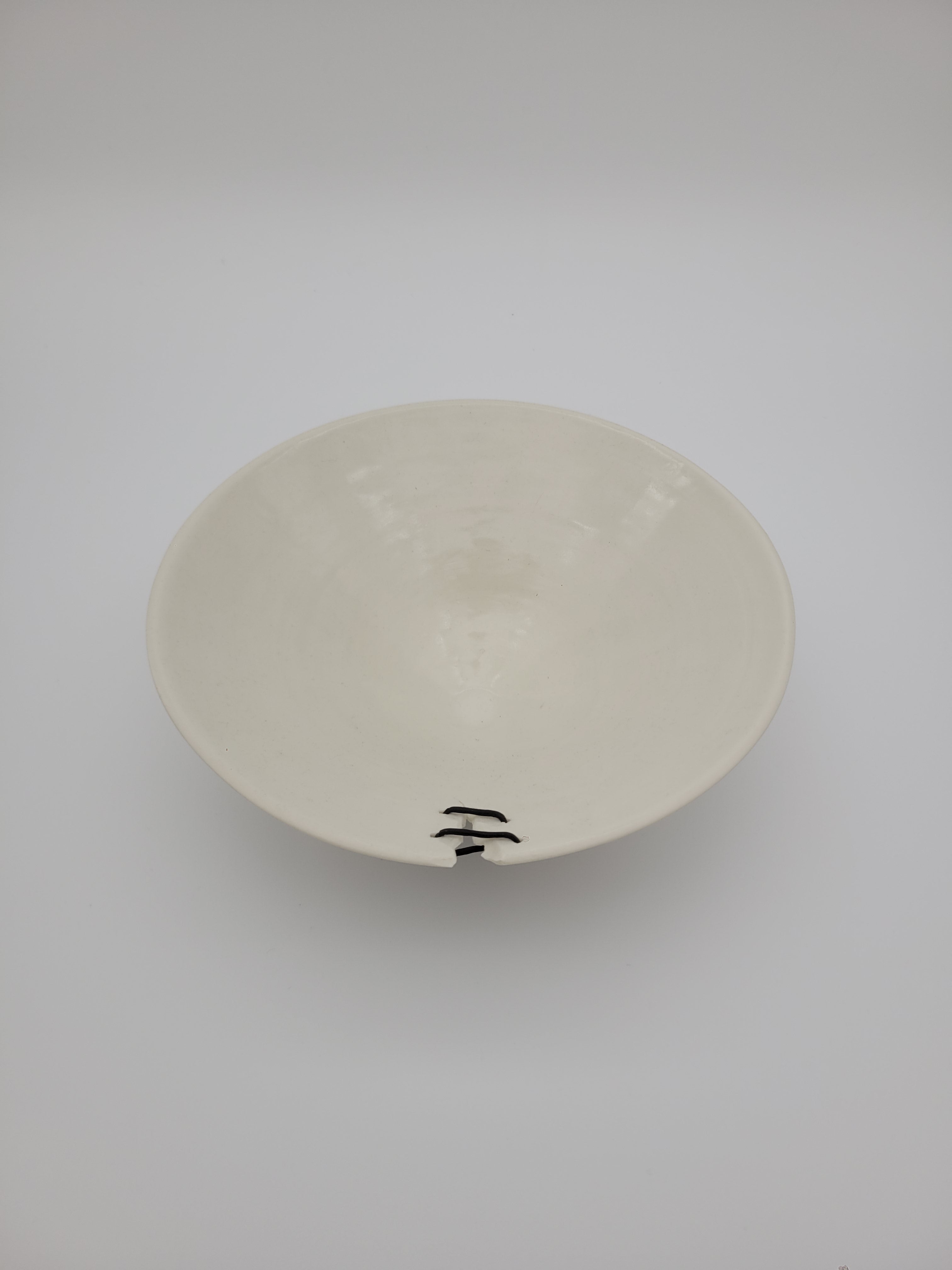 White ceramic bowl, medium size, with filigree detail and decorative opening at rim