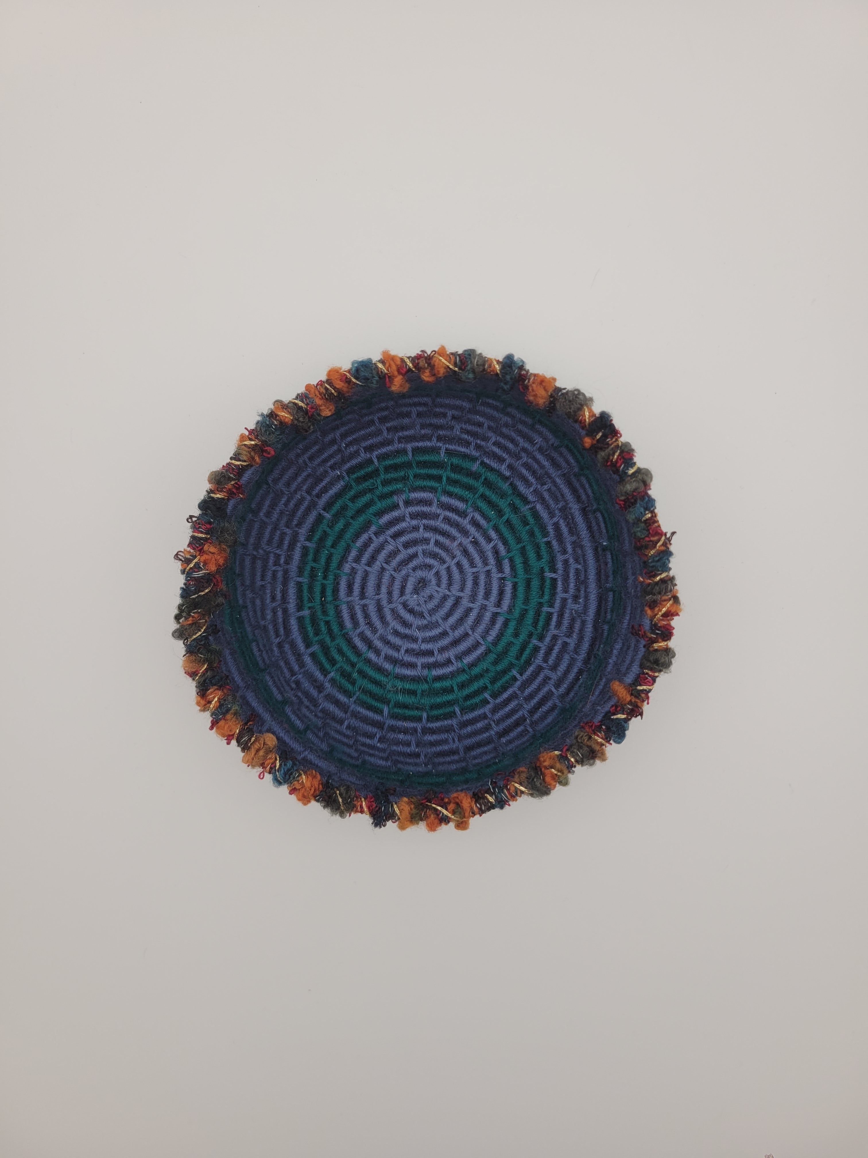 Handmade coiled yarn bowl in blue and green with orange and red details
