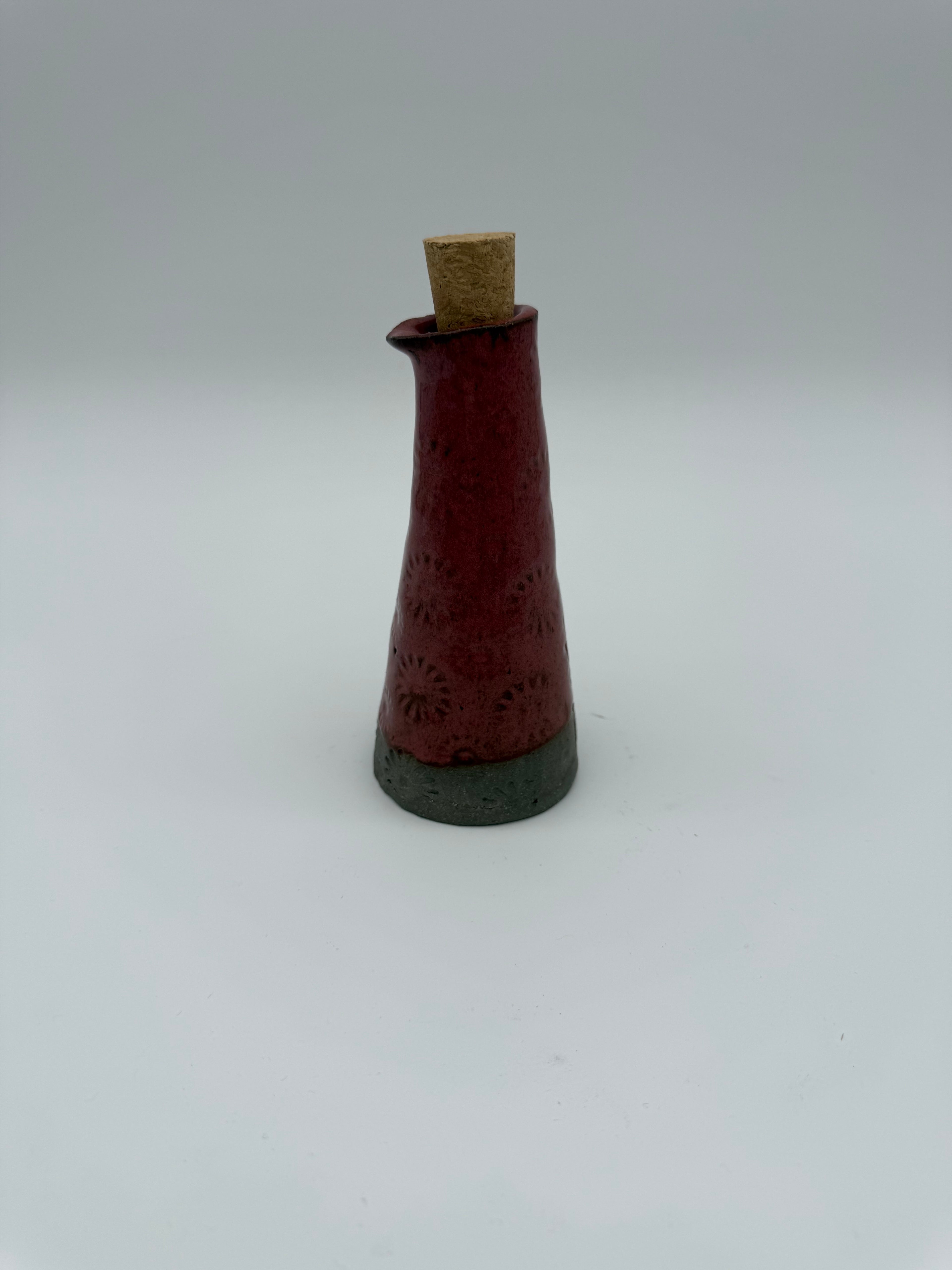 Bottle for oil or vinegar in deep pink glaze with floral design