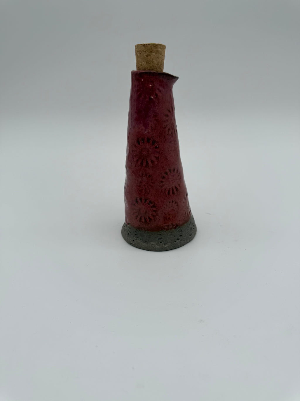 Bottle for oil or vinegar in deep pink glaze with floral design