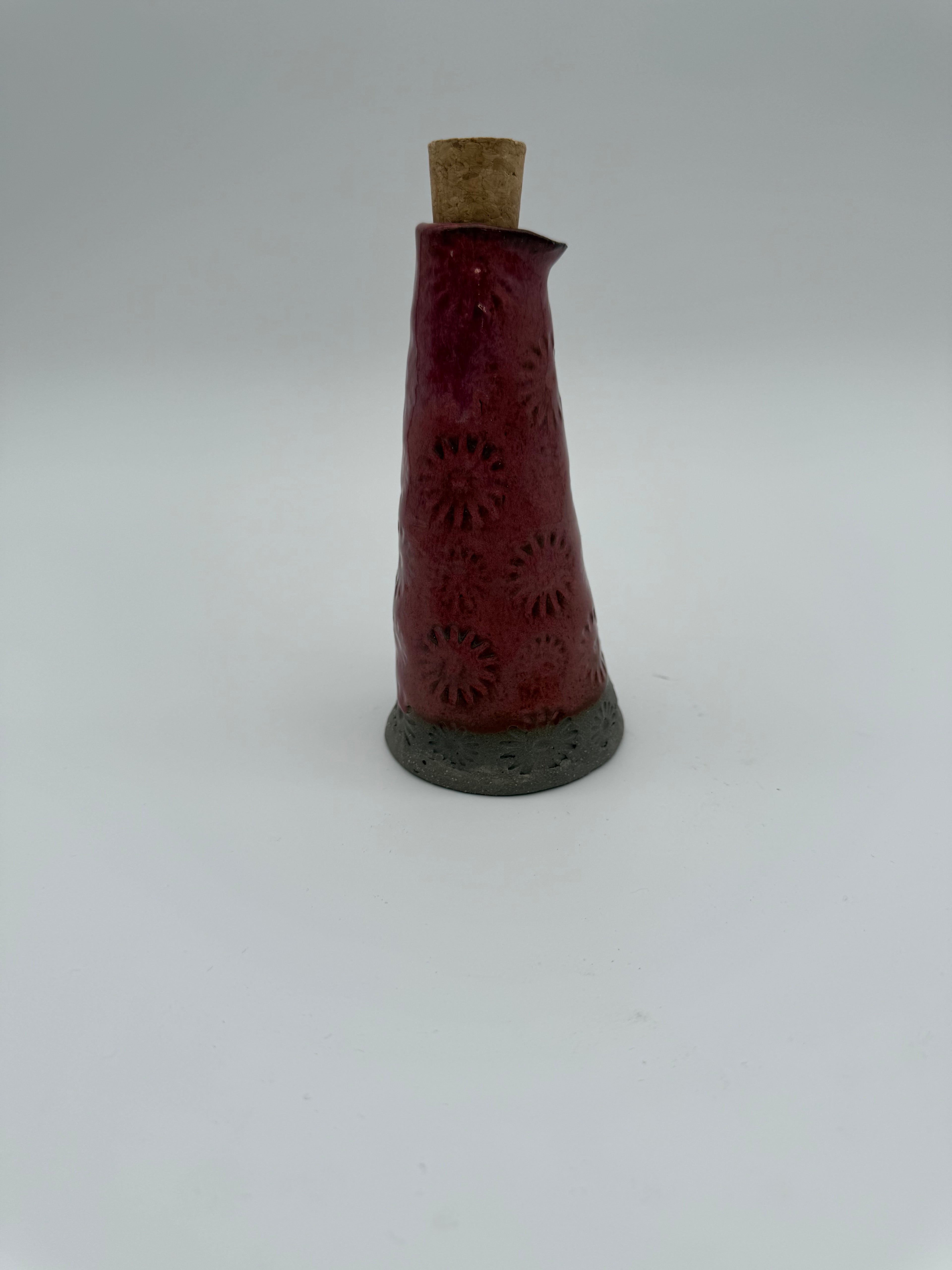 Bottle for oil or vinegar in deep pink glaze with floral design