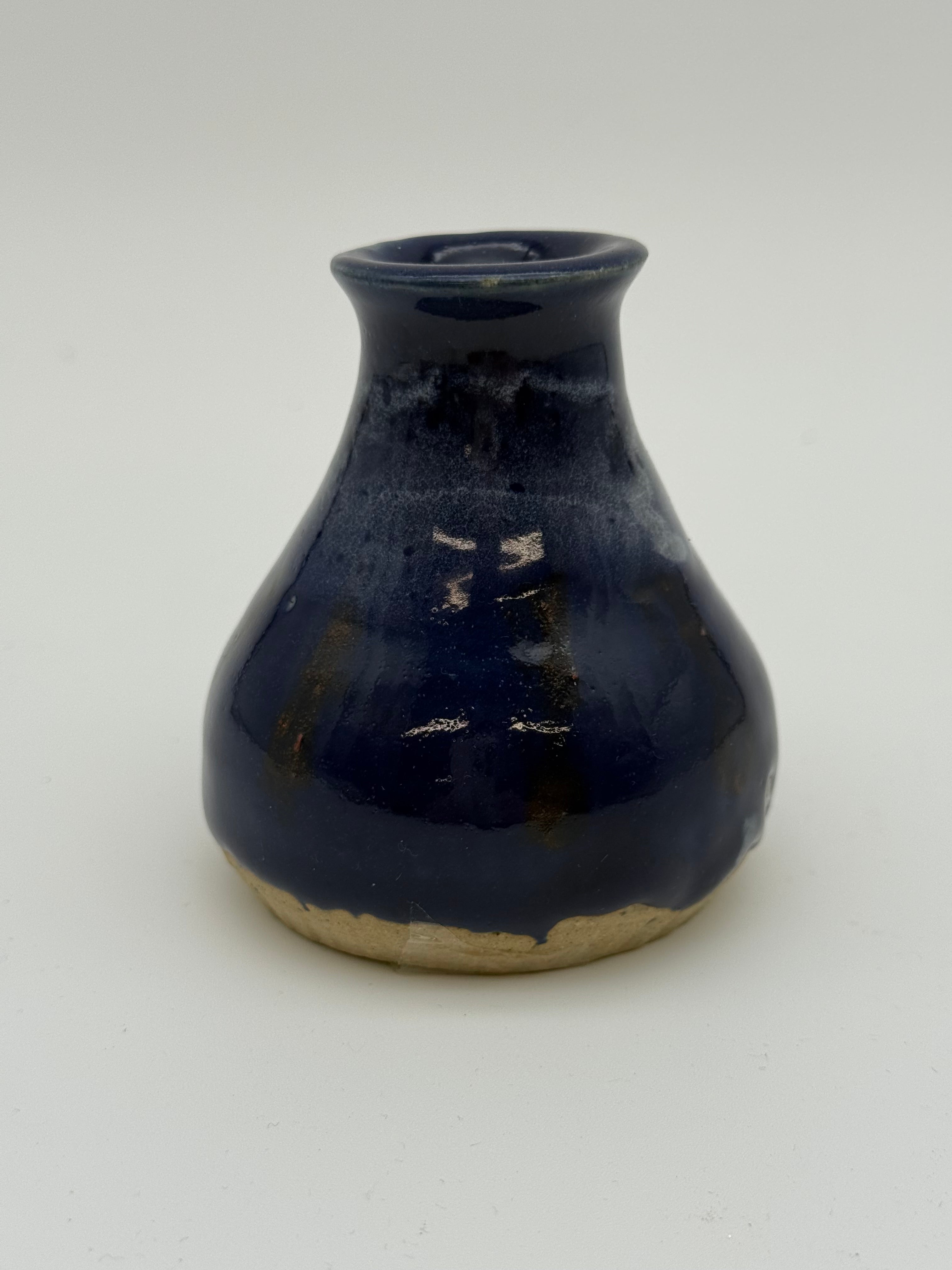 Blue glazed bud vase with white detail at collar
