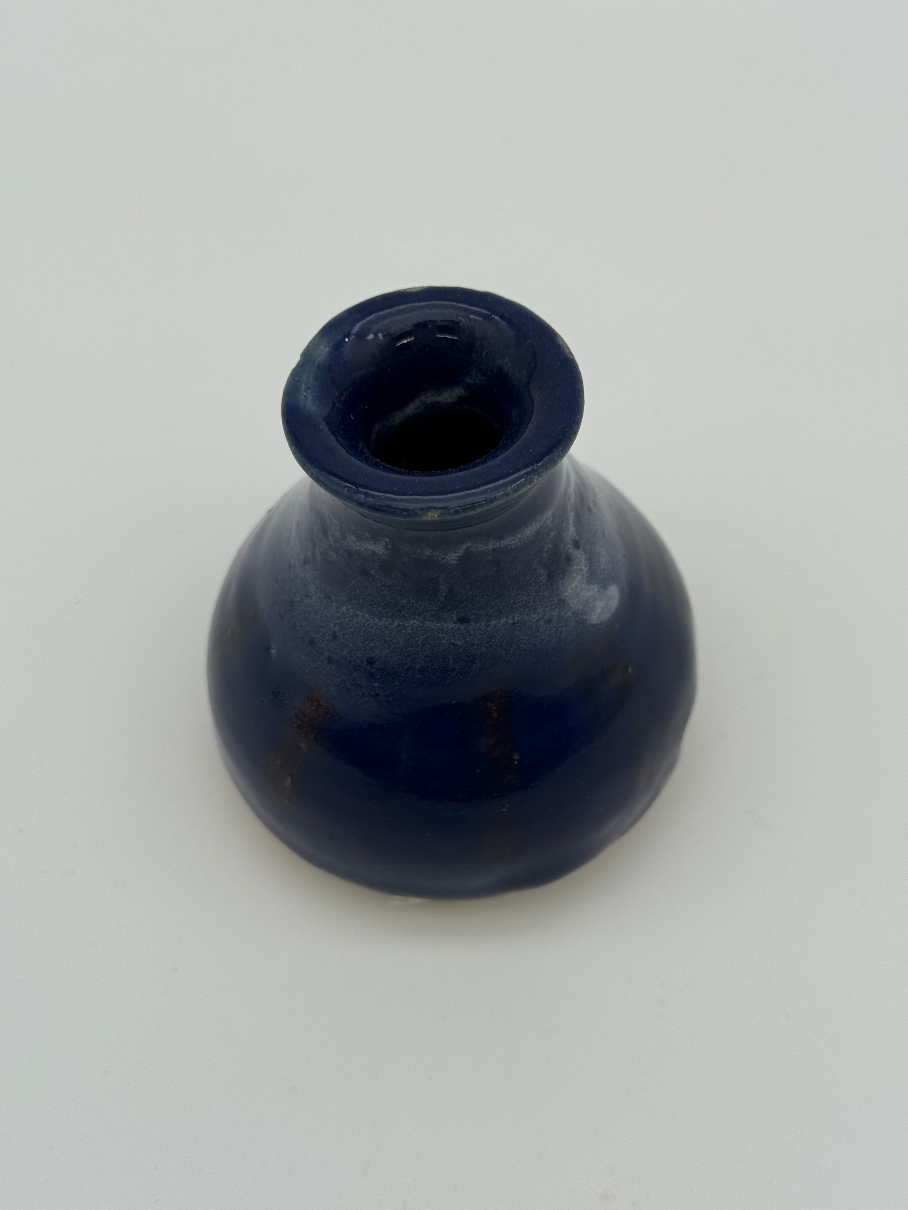 Blue glazed bud vase with white detail at collar